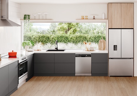 Modern kitchen with Westinghouse stainless steel appliances, including built-in oven, dishwasher, and French door fridge, featuring dark grey cabinets, white countertops, and garden-facing windows.