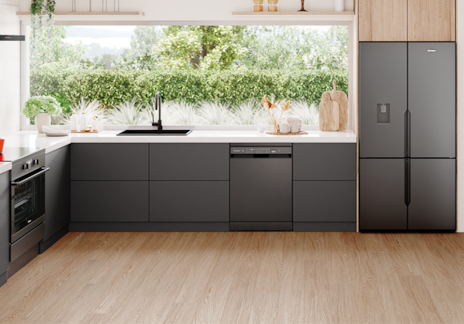 : Stylish kitchen with Westinghouse built-in appliances, including oven, dishwasher, and double-door fridge, featuring dark grey cabinets, white countertops, and open shelving with natural light from garden-facing windows.